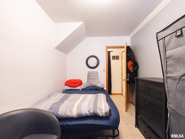 bedroom featuring light tile patterned floors, visible vents, and a textured ceiling