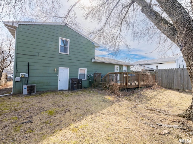 rear view of house with a deck, fence, and central AC