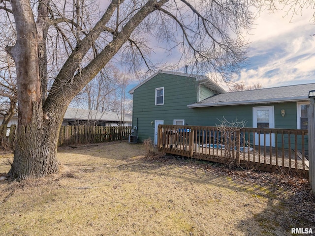 back of property with a wooden deck, fence, and a shingled roof