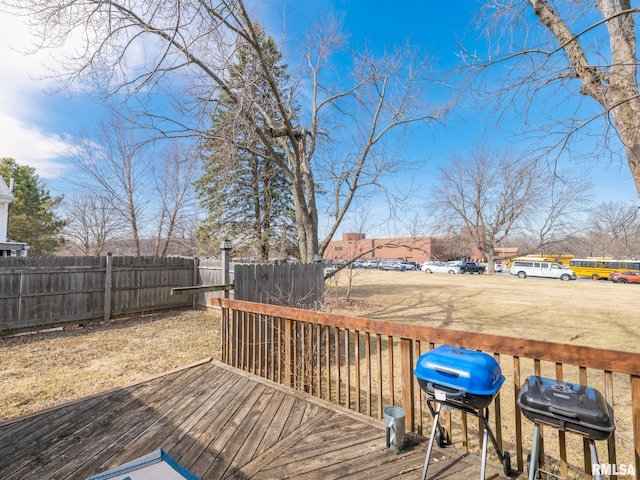 wooden terrace featuring a grill and fence