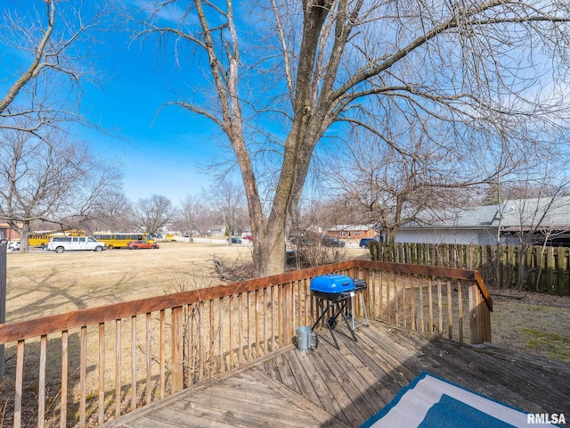 wooden terrace with a grill and fence