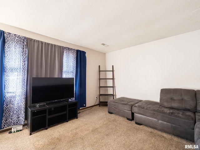 living area featuring carpet flooring, a textured ceiling, and visible vents