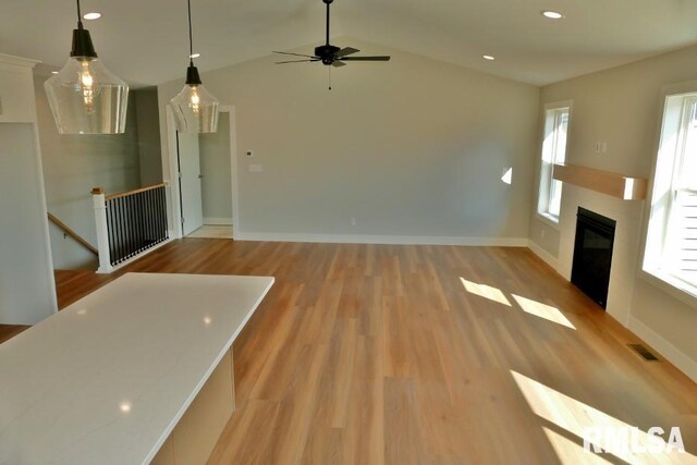 kitchen with stainless steel microwave, pendant lighting, ceiling fan, and white cabinetry