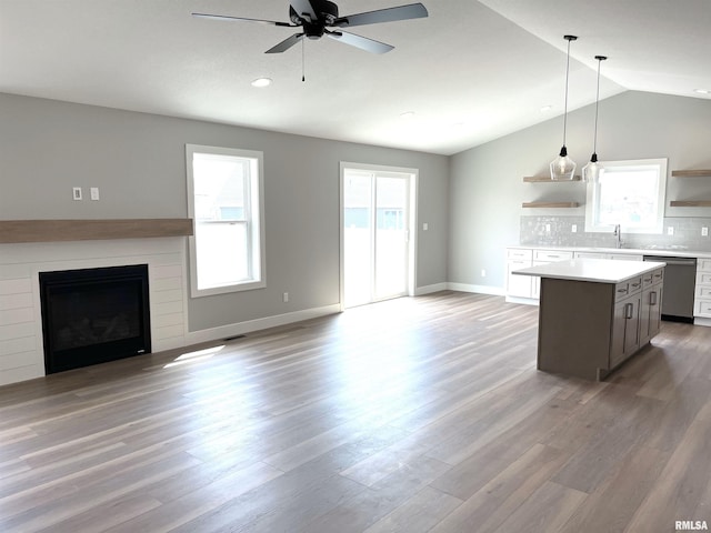 kitchen featuring stainless steel dishwasher, a ceiling fan, open shelves, and open floor plan