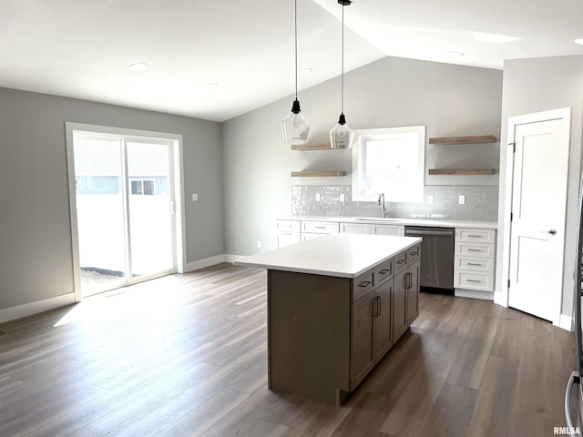kitchen with plenty of natural light, stainless steel dishwasher, open shelves, light countertops, and a sink