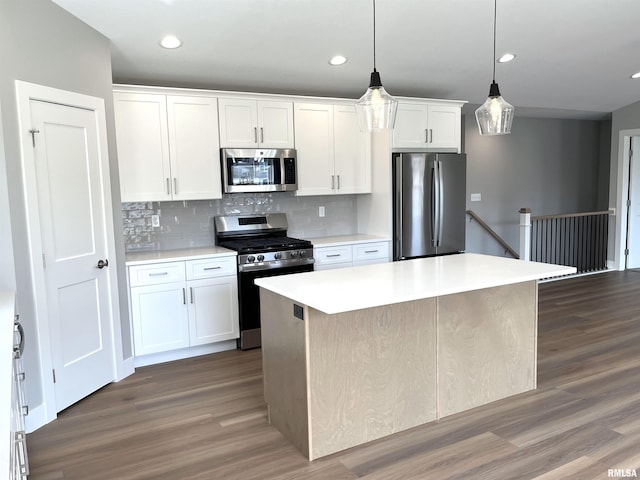 kitchen featuring decorative backsplash, light countertops, dark wood-style floors, stainless steel appliances, and white cabinetry