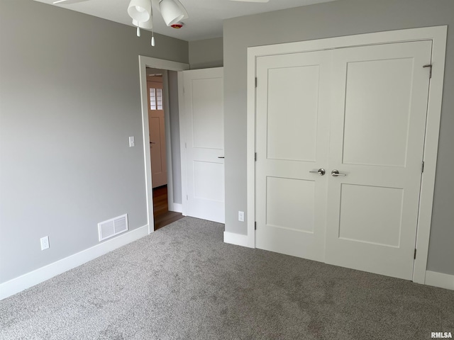 unfurnished bedroom featuring baseboards, carpet, a closet, and visible vents
