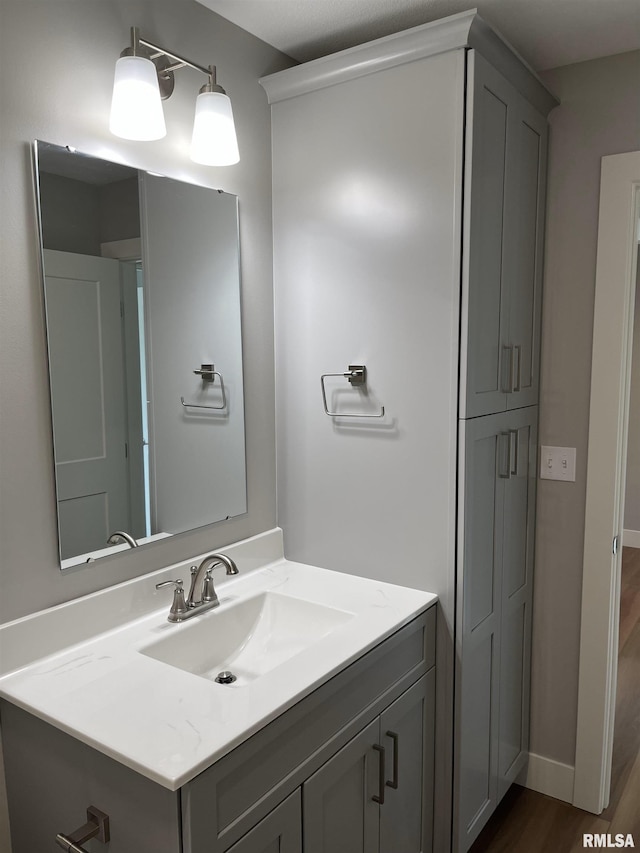 bathroom with vanity, baseboards, and wood finished floors