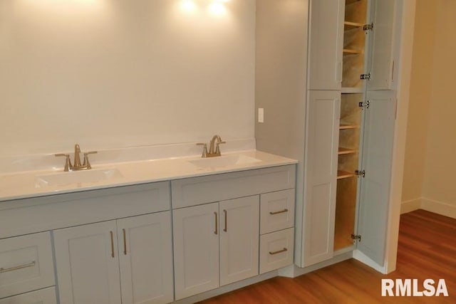 full bath with wood finished floors, baseboards, and a sink