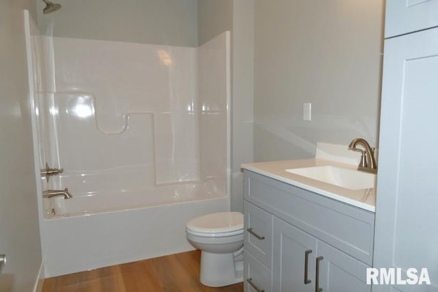 bathroom featuring vanity, washtub / shower combination, toilet, and wood finished floors