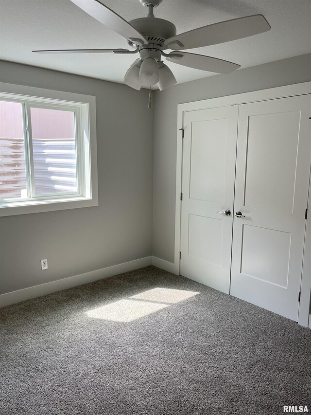 unfurnished bedroom featuring carpet floors, baseboards, a closet, and ceiling fan