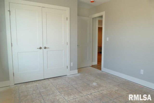 unfurnished bedroom with baseboards and a closet