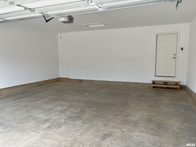garage with baseboards and a garage door opener