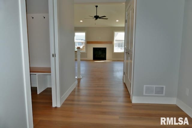 corridor featuring recessed lighting, wood finished floors, visible vents, and baseboards