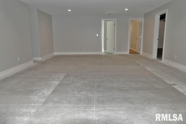 spare room featuring recessed lighting and baseboards