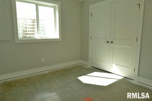 unfurnished bedroom with a closet and baseboards