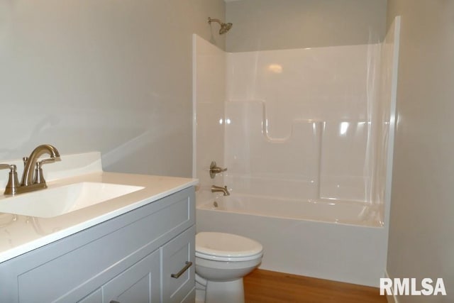 bathroom featuring vanity, toilet, shower / bathing tub combination, and wood finished floors