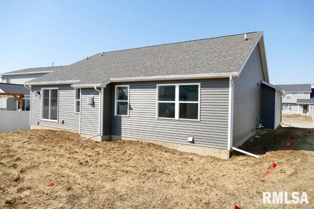 rear view of house with fence and roof with shingles