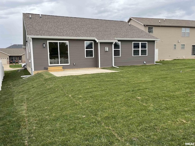 back of house featuring a patio, a shingled roof, and a yard