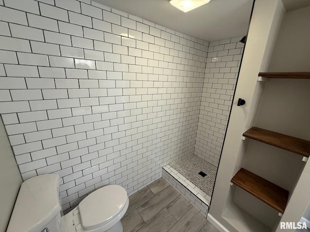 full bathroom featuring a shower stall, toilet, and wood tiled floor