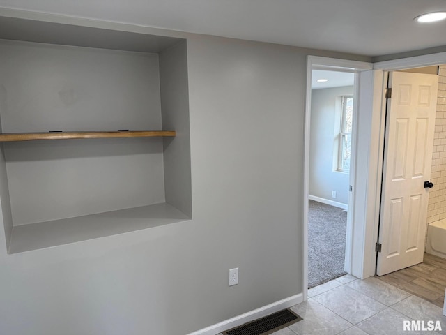 hallway featuring recessed lighting, light tile patterned flooring, baseboards, and visible vents