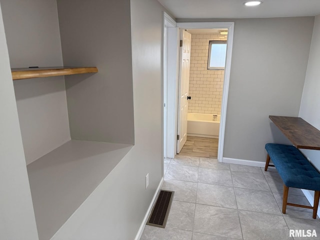 corridor with recessed lighting, visible vents, baseboards, and light tile patterned flooring