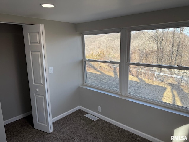 unfurnished room with recessed lighting, baseboards, visible vents, and dark carpet