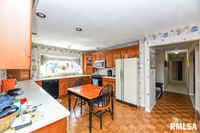 kitchen with brown cabinets, black appliances, and light countertops