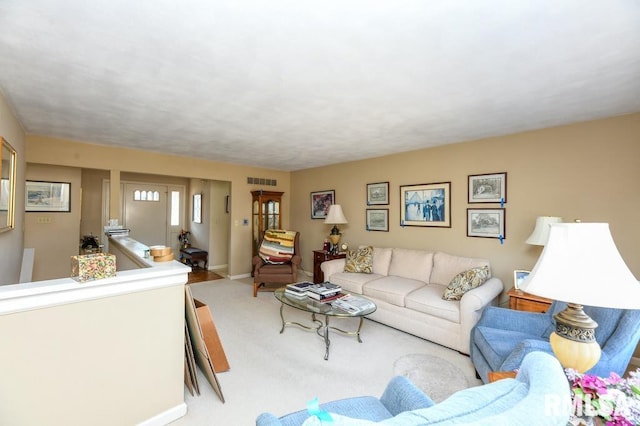 living room with visible vents, baseboards, and carpet flooring