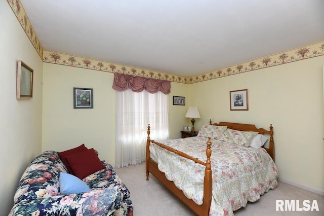 bedroom with light colored carpet and baseboards