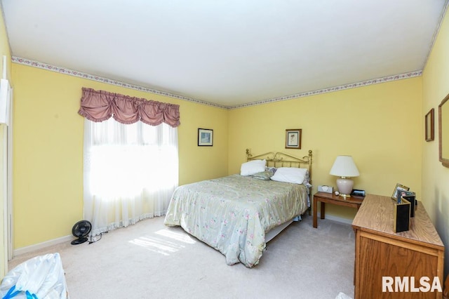 bedroom with baseboards and light colored carpet