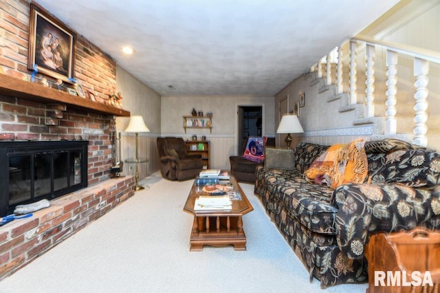 carpeted living room with stairway and a fireplace