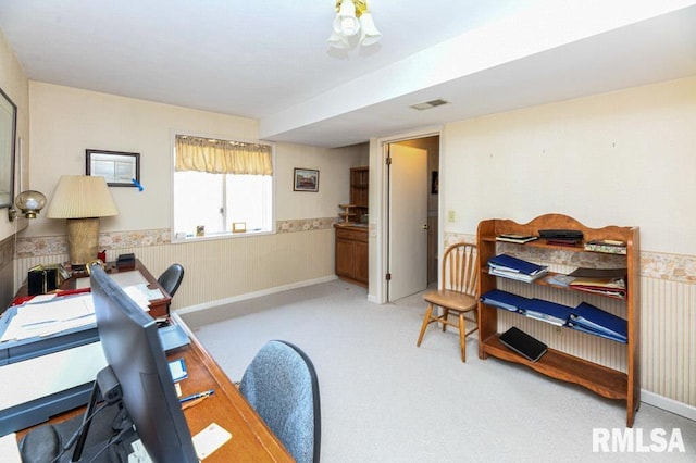 carpeted office with visible vents and a wainscoted wall