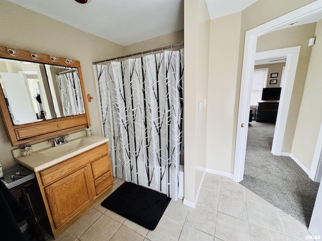 bathroom with vanity, tile patterned floors, baseboards, and a shower with shower curtain