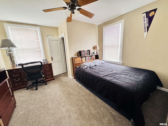 bedroom with ceiling fan, baseboards, carpet, and multiple windows