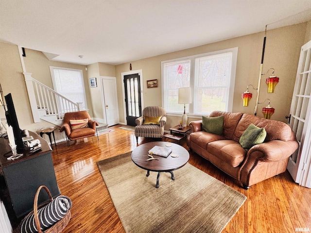 living room featuring stairs and light wood-style flooring