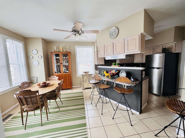 kitchen with visible vents, baseboards, ceiling fan, light tile patterned floors, and freestanding refrigerator