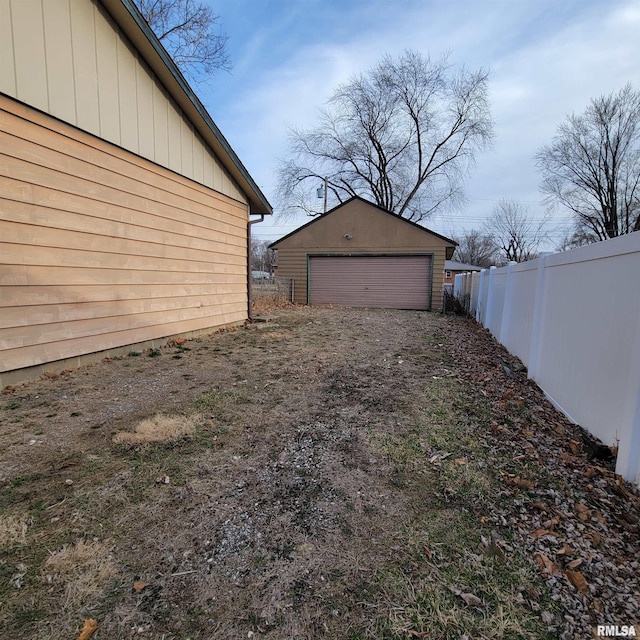 view of yard featuring a garage, an outdoor structure, and fence