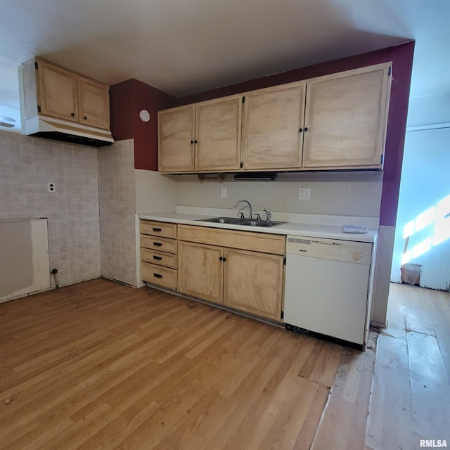 kitchen with light brown cabinets, white dishwasher, a sink, light countertops, and light wood-type flooring