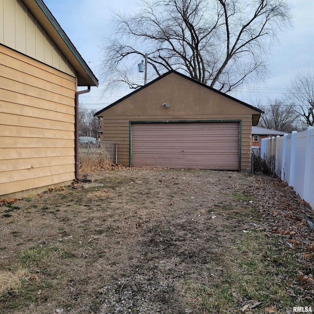 detached garage featuring fence