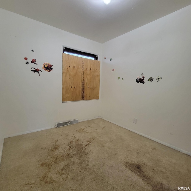 carpeted spare room with visible vents and baseboards