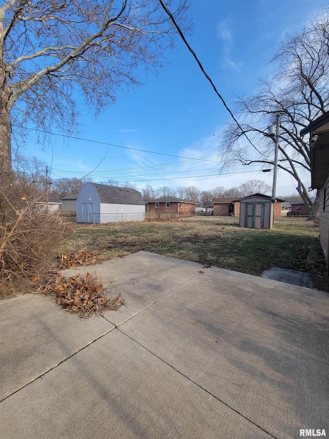 view of yard with a patio, an outdoor structure, and a shed