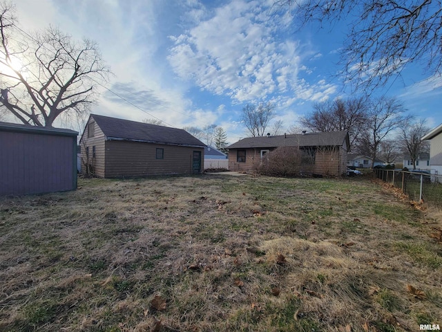 view of yard featuring an outbuilding and fence