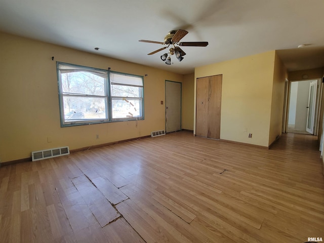 unfurnished room featuring baseboards, a ceiling fan, visible vents, and light wood-type flooring