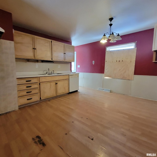 kitchen featuring light wood finished floors, visible vents, light brown cabinets, white dishwasher, and a sink