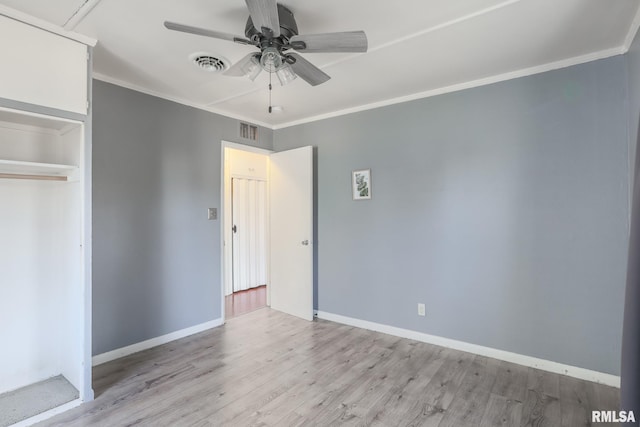 unfurnished bedroom featuring light wood finished floors, visible vents, and crown molding