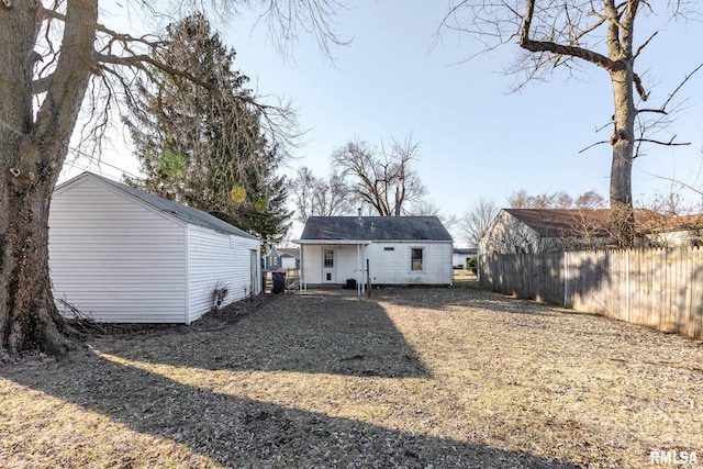 back of house with an outbuilding and fence