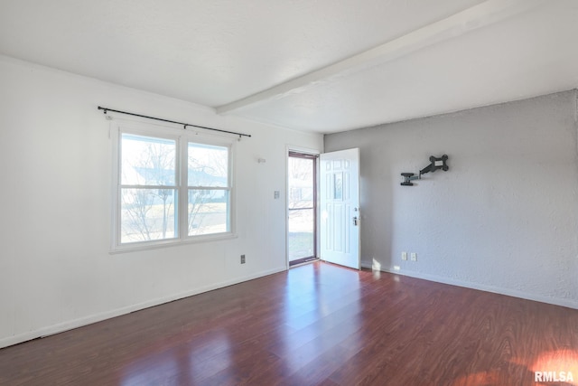 empty room with dark wood-style floors, beamed ceiling, baseboards, and a textured wall