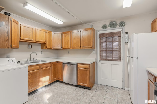 kitchen with washer / dryer, freestanding refrigerator, a sink, light countertops, and stainless steel dishwasher