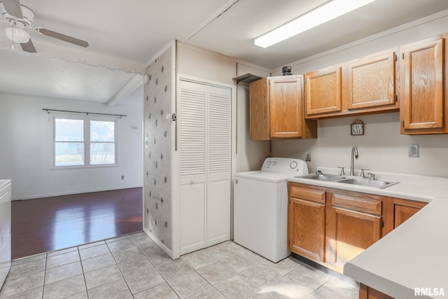 clothes washing area featuring light tile patterned floors, a ceiling fan, washer / dryer, cabinet space, and a sink